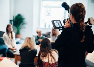 woman holding camera standing near people